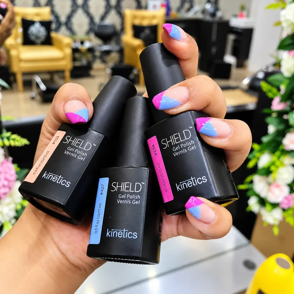 Colourful manicure holding polish bottles